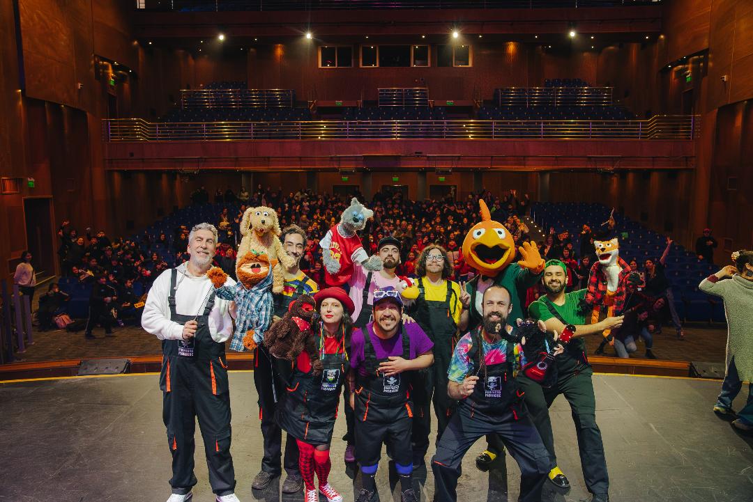 Integrantes de Proyecto Pichiche y personajes de “El Baúl del Pajarraco” frente a estudiantes en el Teatro Municipal de Chillán.