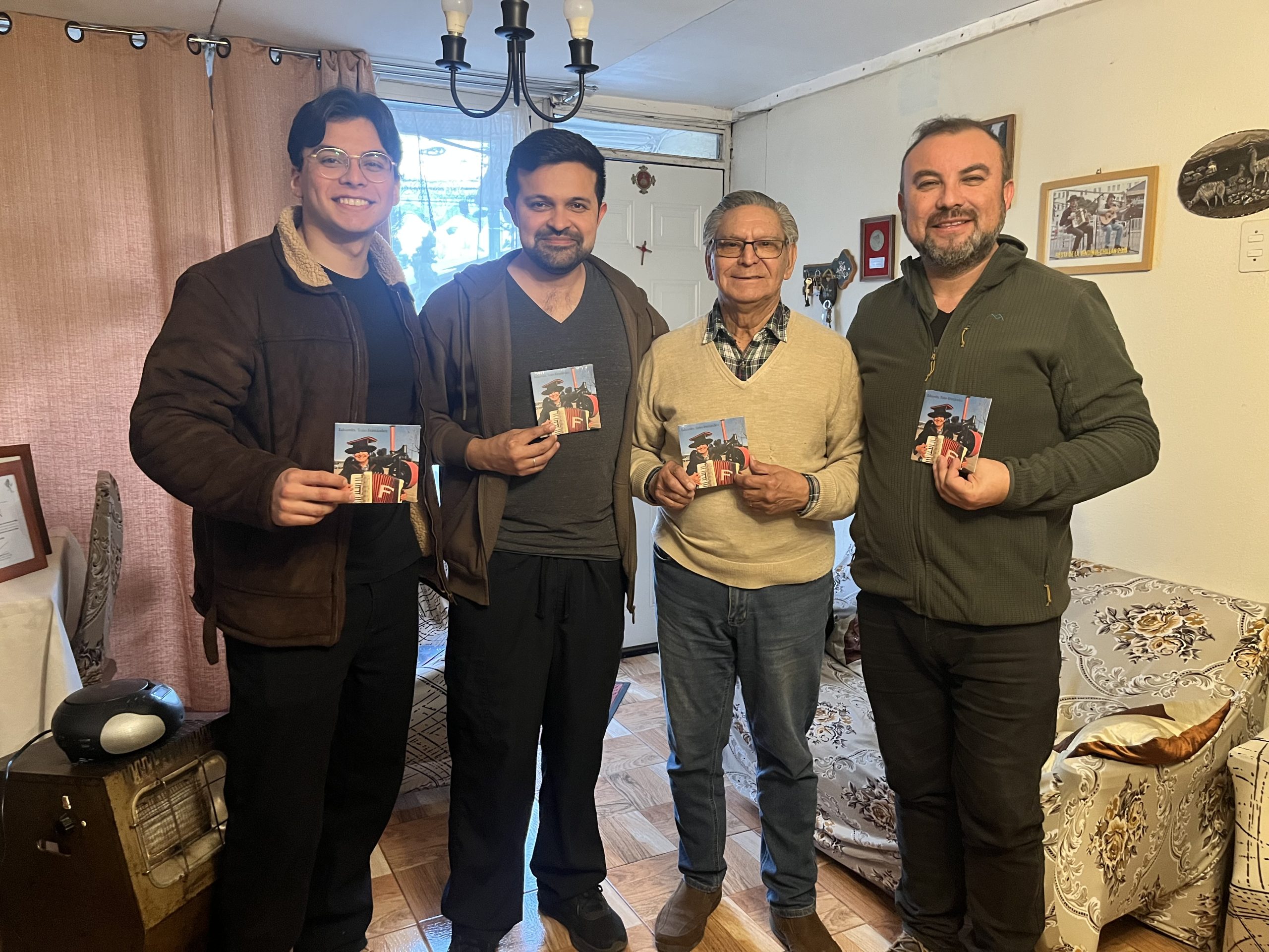 Eduardo “Toño” Fernández junto a tres integrantes del equipo mostrando copias de su nuevo disco.