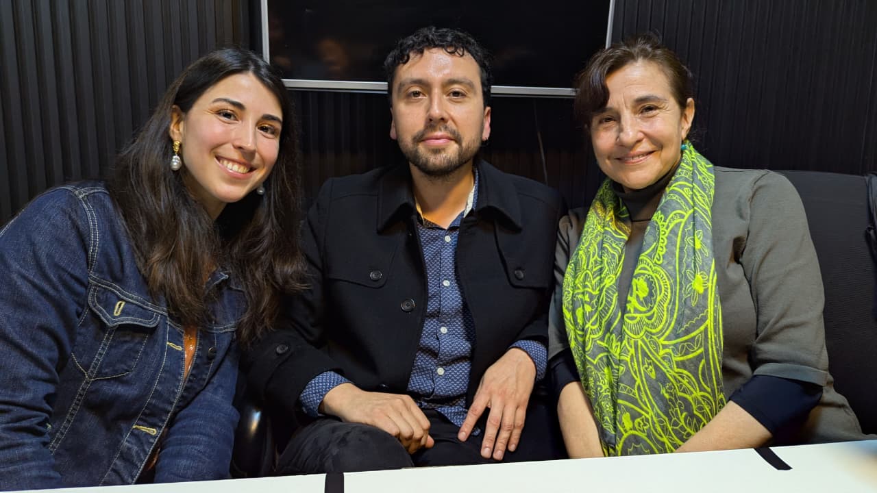 Ximena Godoy, Eden Rodríguez y Julieta Herrera posan juntos, sentados ante una mesa en un estudio de radio.